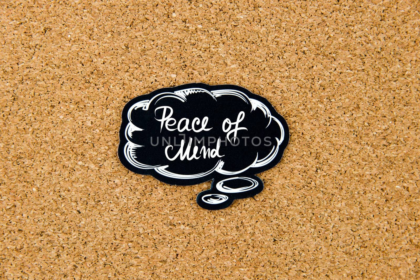 PEACE OF MIND written on black thinking bubble over cork board background, copy space available