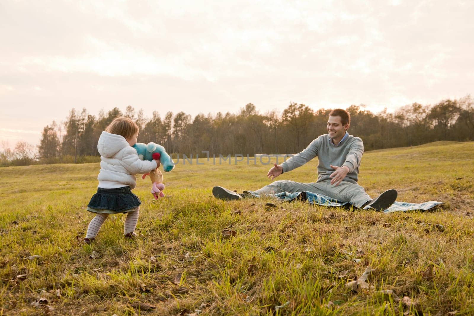 little daughter running to her beloved father with a bunch of puppets and toys