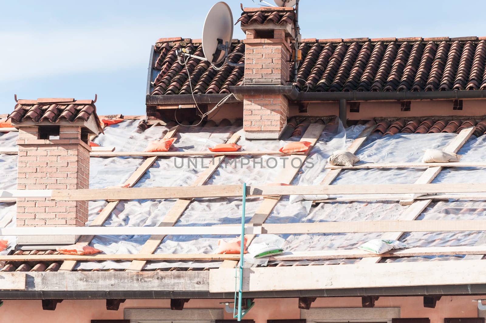 Emergency repair of a roof with plastic sheeting.