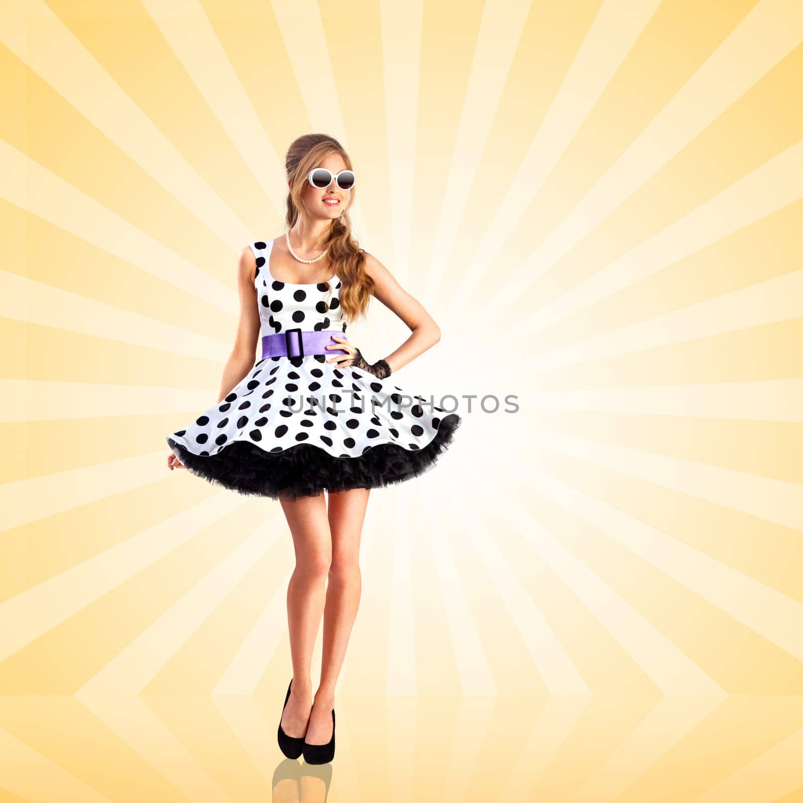 Creative photo of a vogue pin-up girl, dressed in a retro polka-dot dress and sunglasses, posing on colorful abstract cartoon style background.