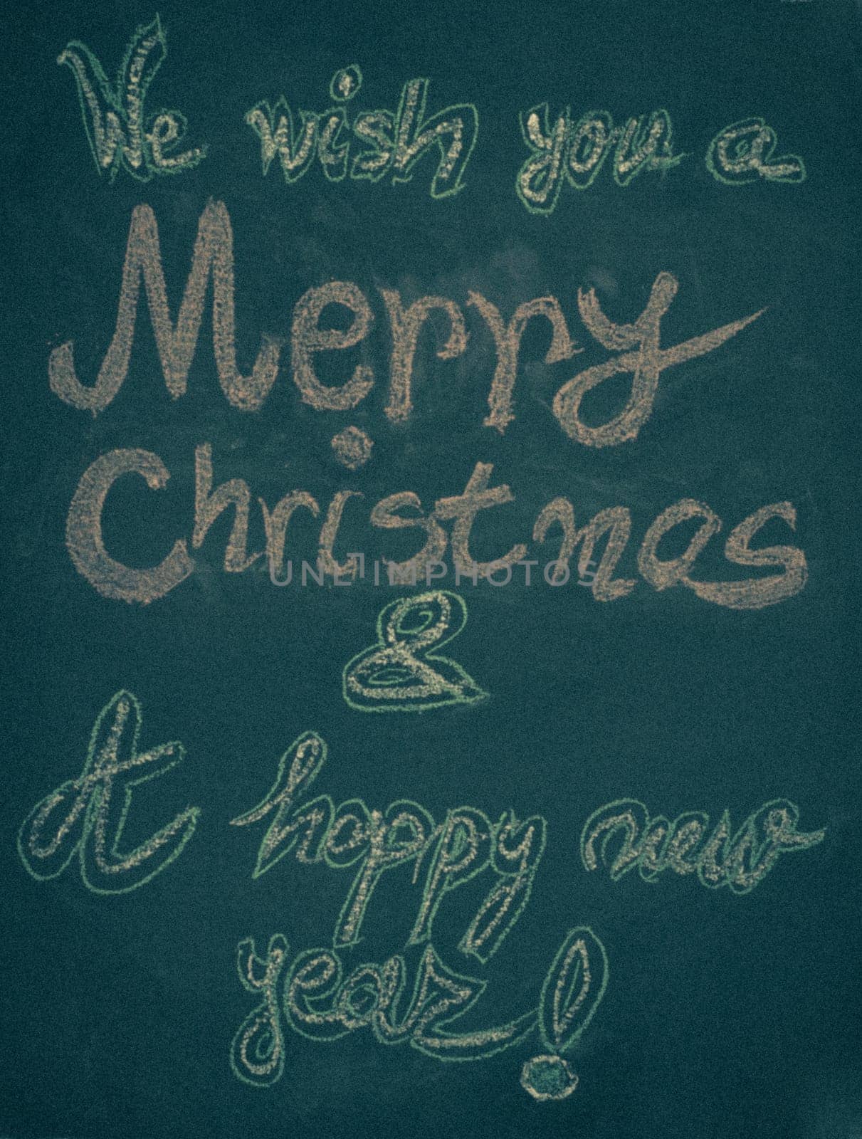 We wish you a Merry Christmas and a happy new year, hand writing with chalk on blackboard, vintage concept
