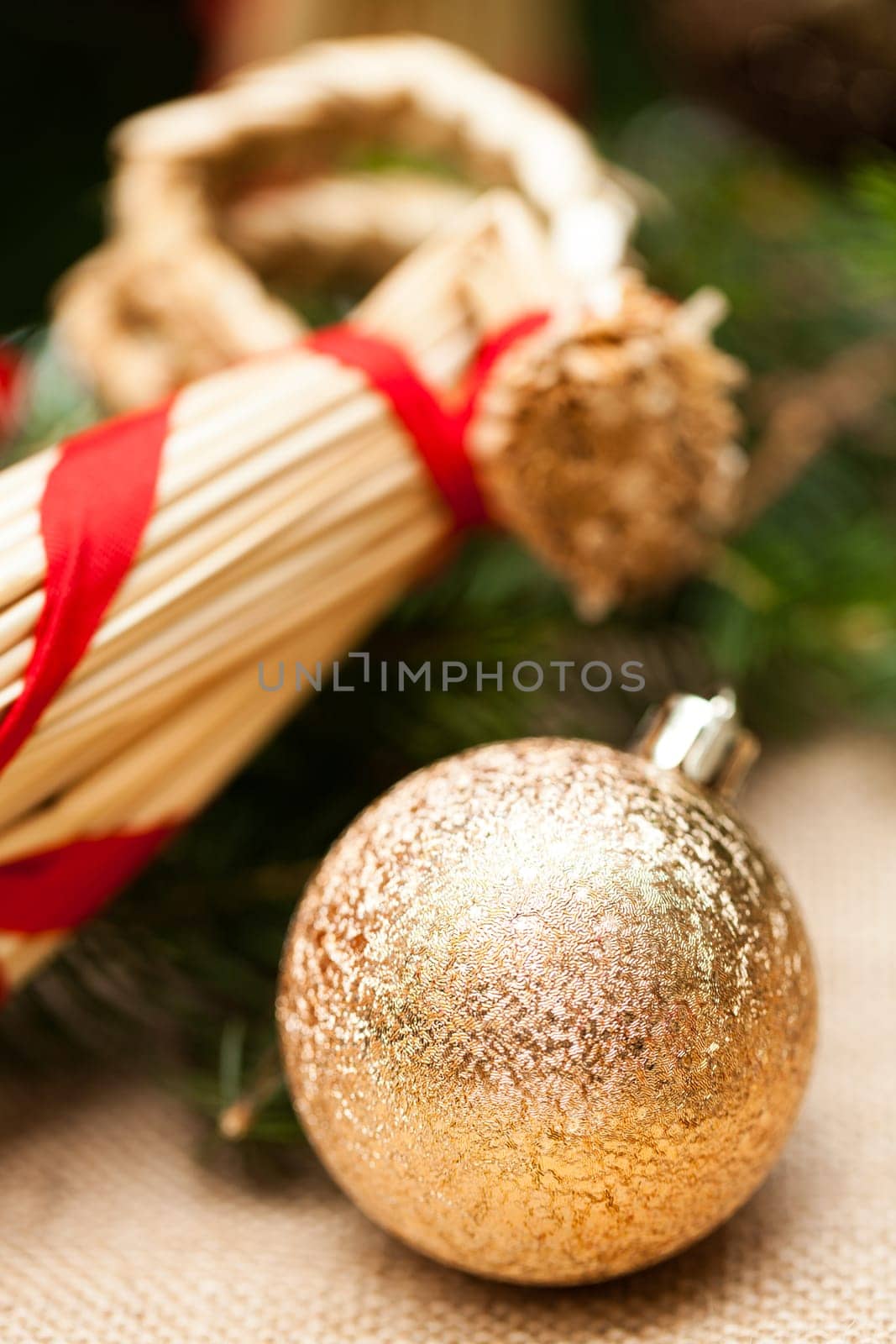 golden Christmas tree balls glittering on tannin branches with snow as macro detail