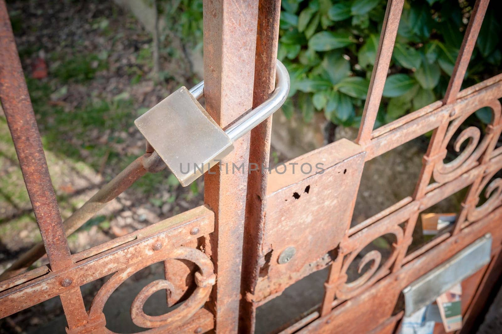 Rusty metal gate closed with padlock - concept image