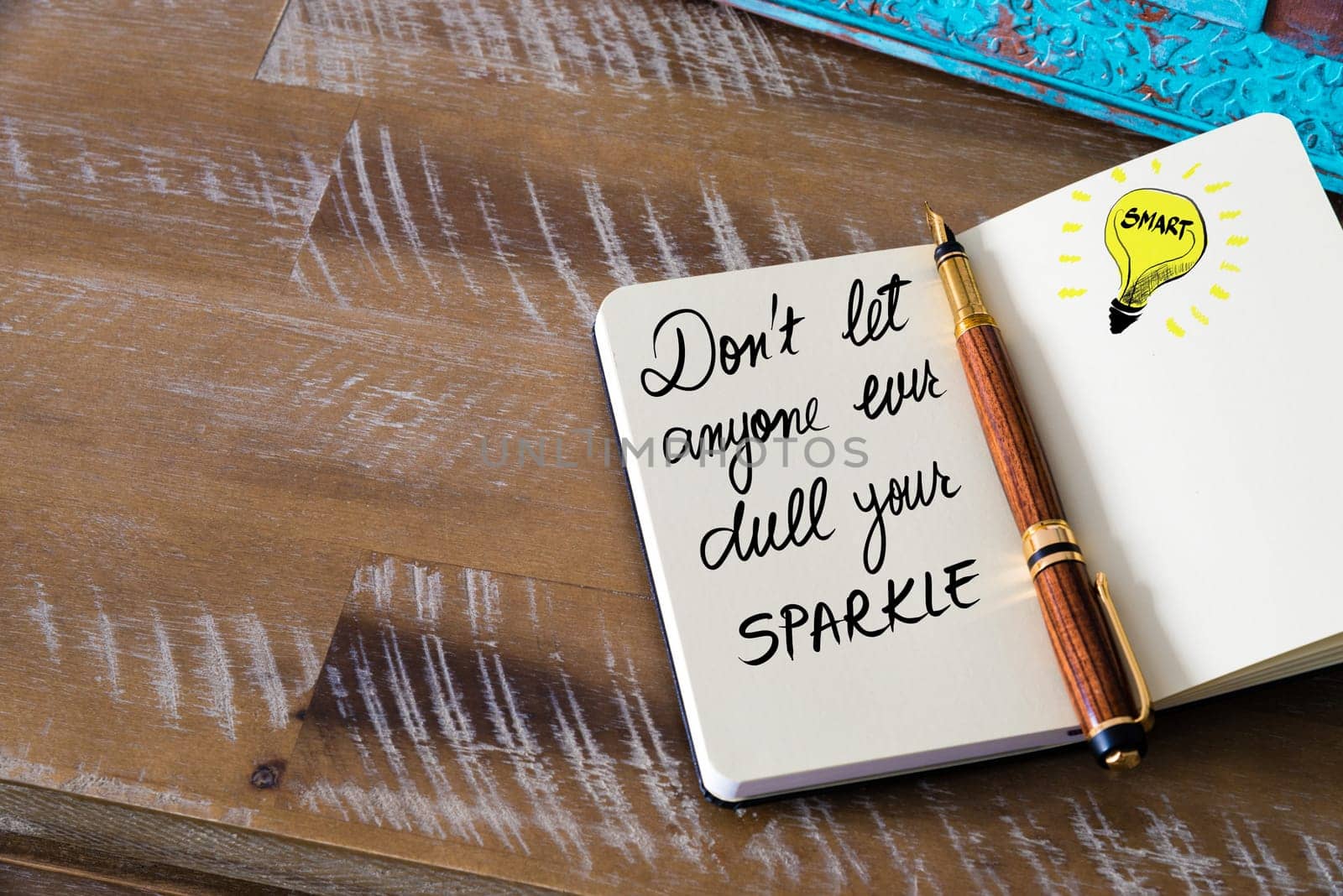 Handwritten text Don’t let anyone ever dull your sparkle with fountain pen on notebook. Concept image with copy space available.
