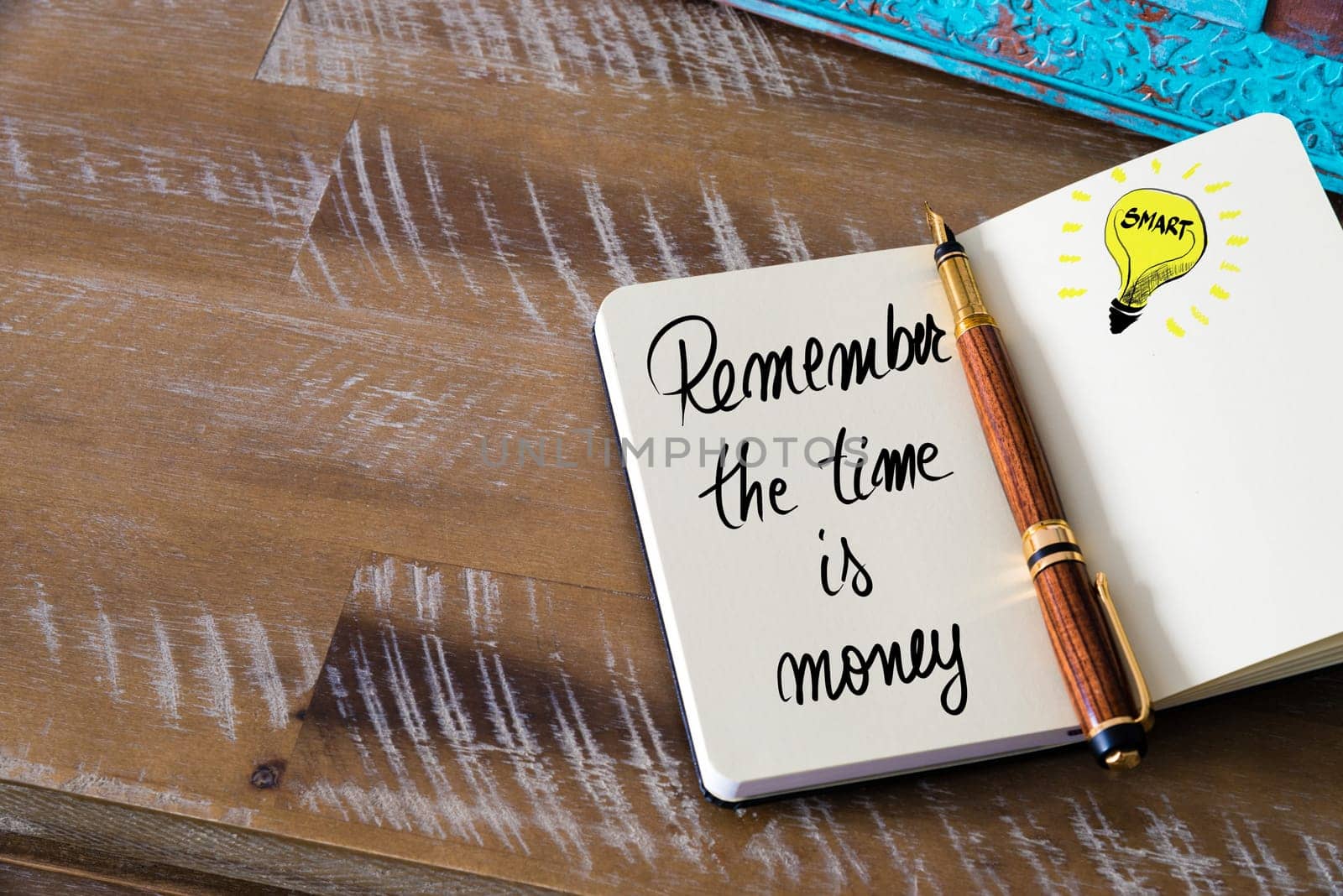 Handwritten text Remember The Time Is Money with fountain pen on notebook. Concept image with copy space available.