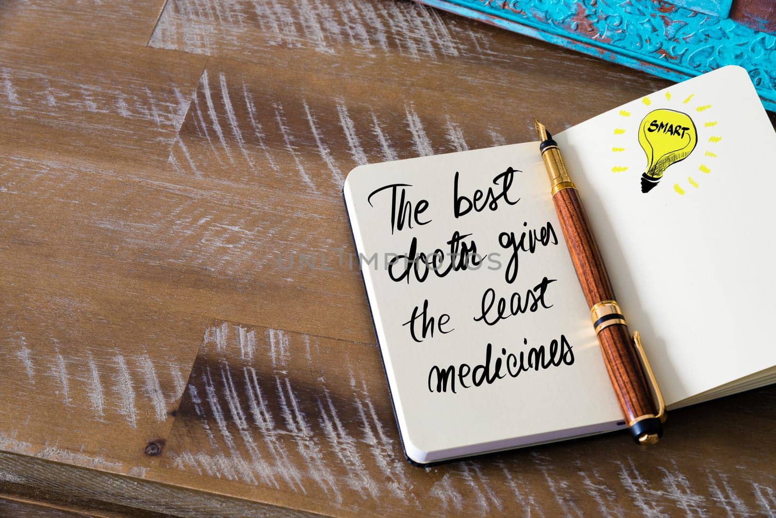Handwritten text The Best Doctor Gives The Least Medicines with fountain pen on notebook. Concept image with copy space available.