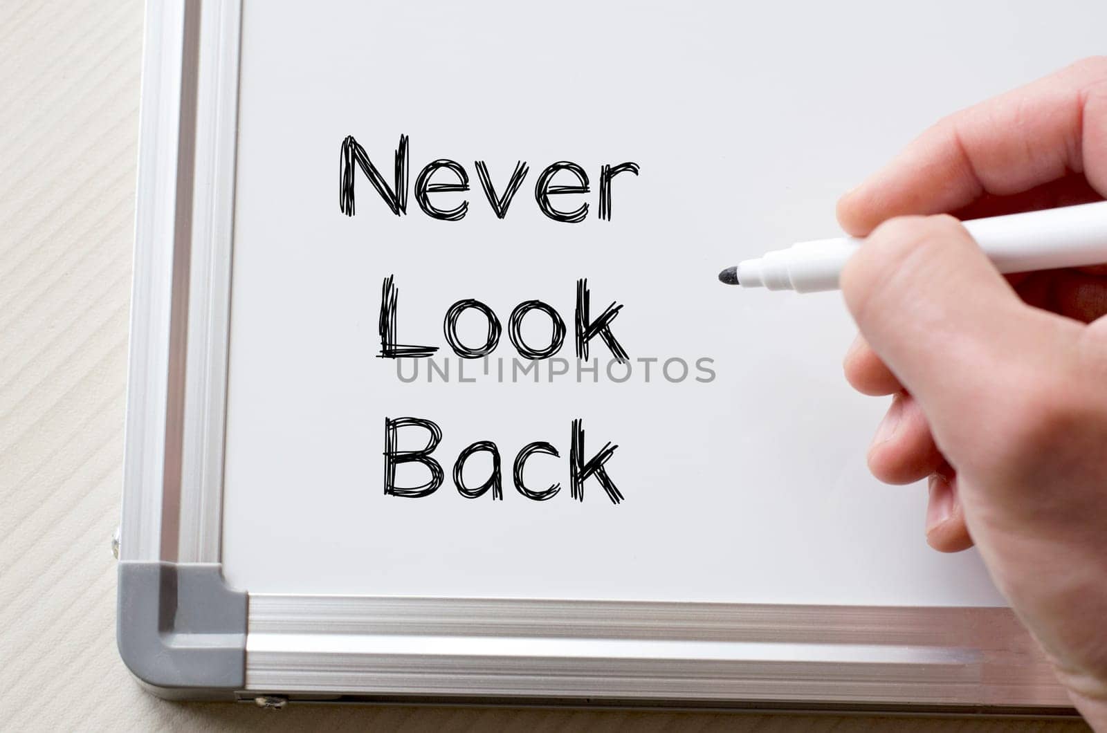 Human hand writing never look back on whiteboard