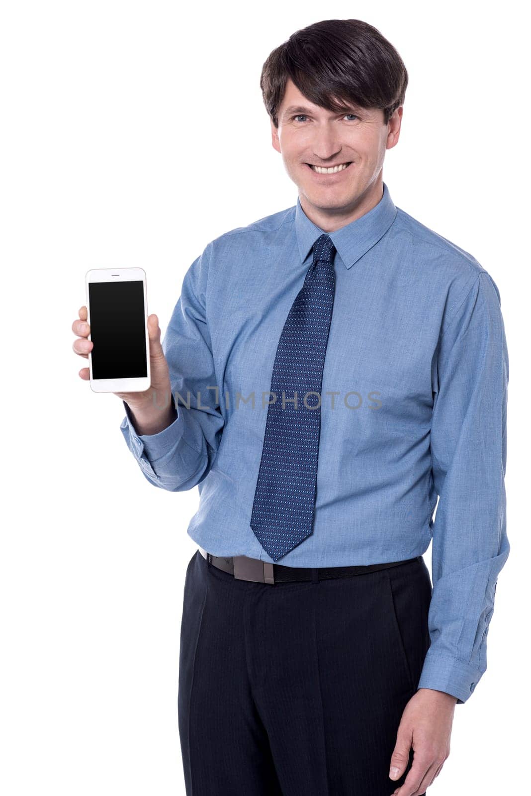 Smiling male executive showing a mobile phone white background.