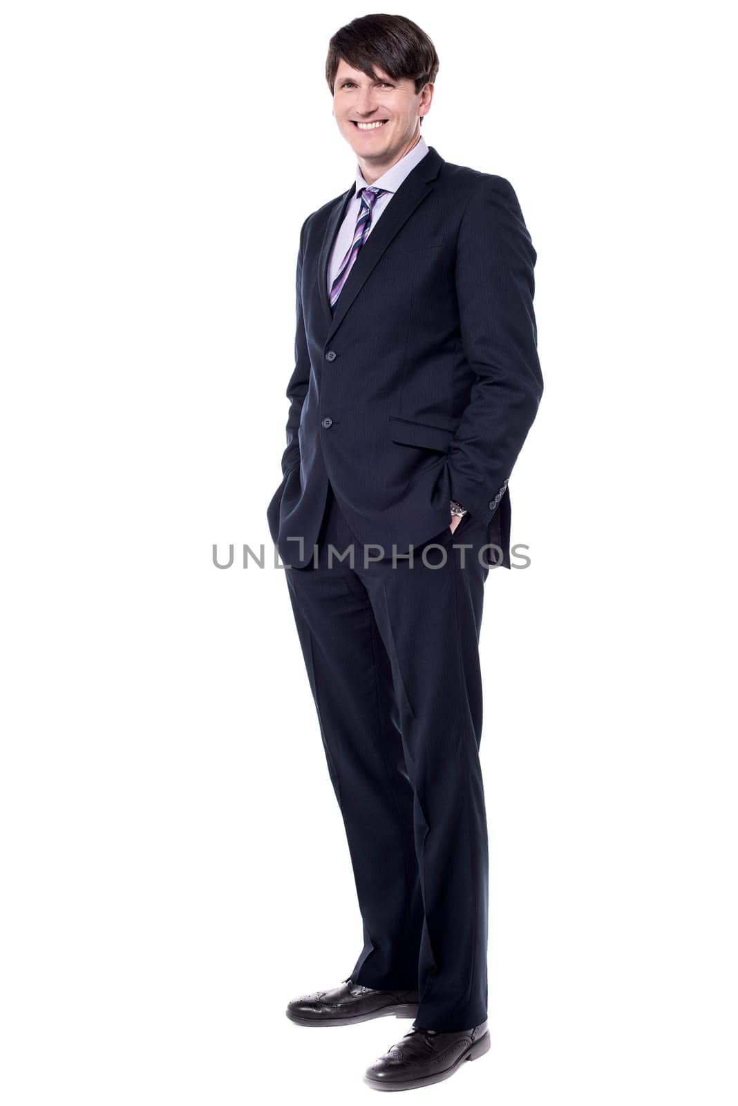 Confident modern businessman keeping his hands in trousers pockets