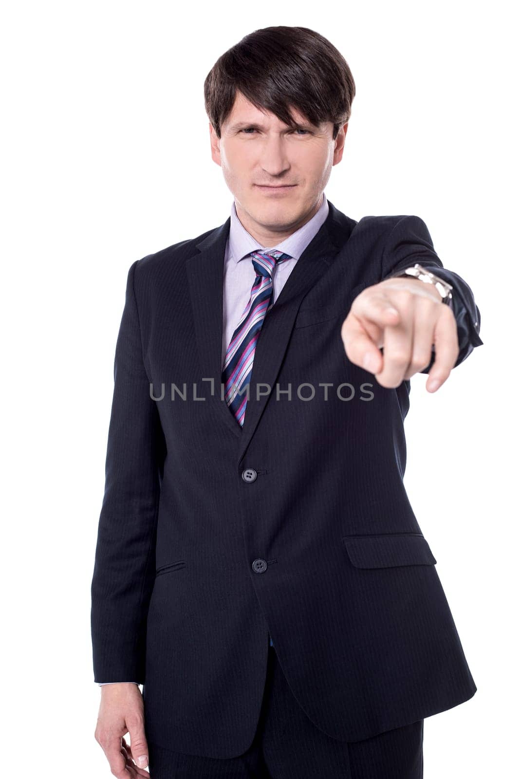 Businessman in black suit looking and pointing finger at camera.