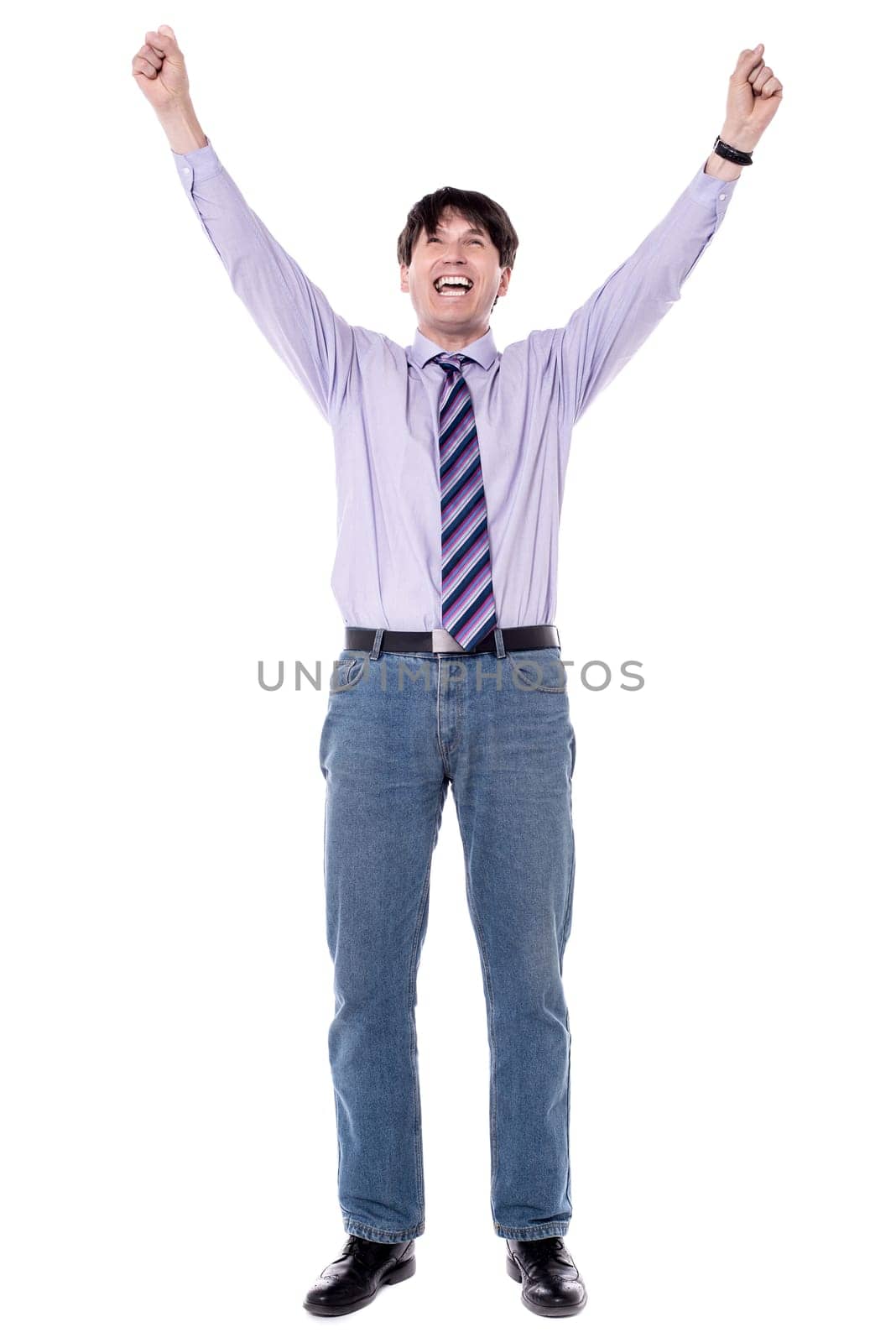 Successful business man raised his arms with clenching fists.