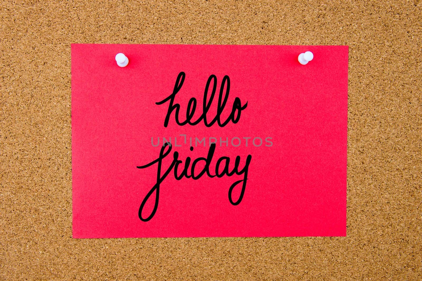 Red paper note with handwritten text Hello Friday pinned on cork board with white thumbtacks
