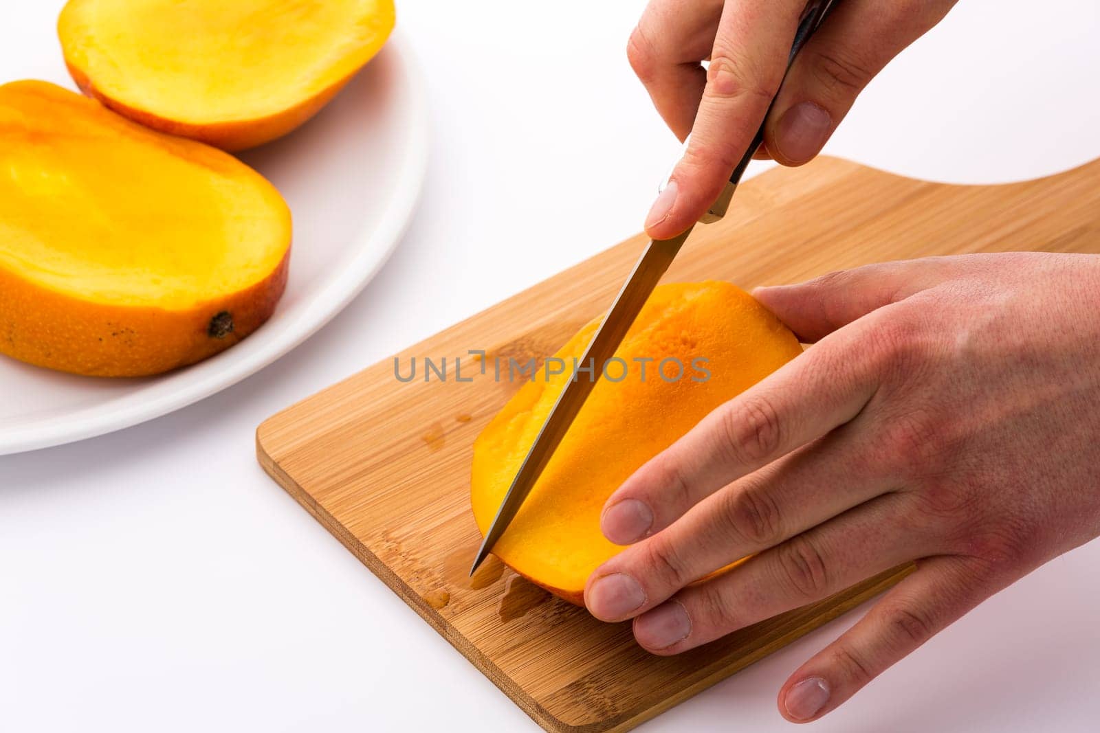 This series of photos shows how best to cut a mango. In a second step, take the three mango slices or thirds and divide them further into chips.