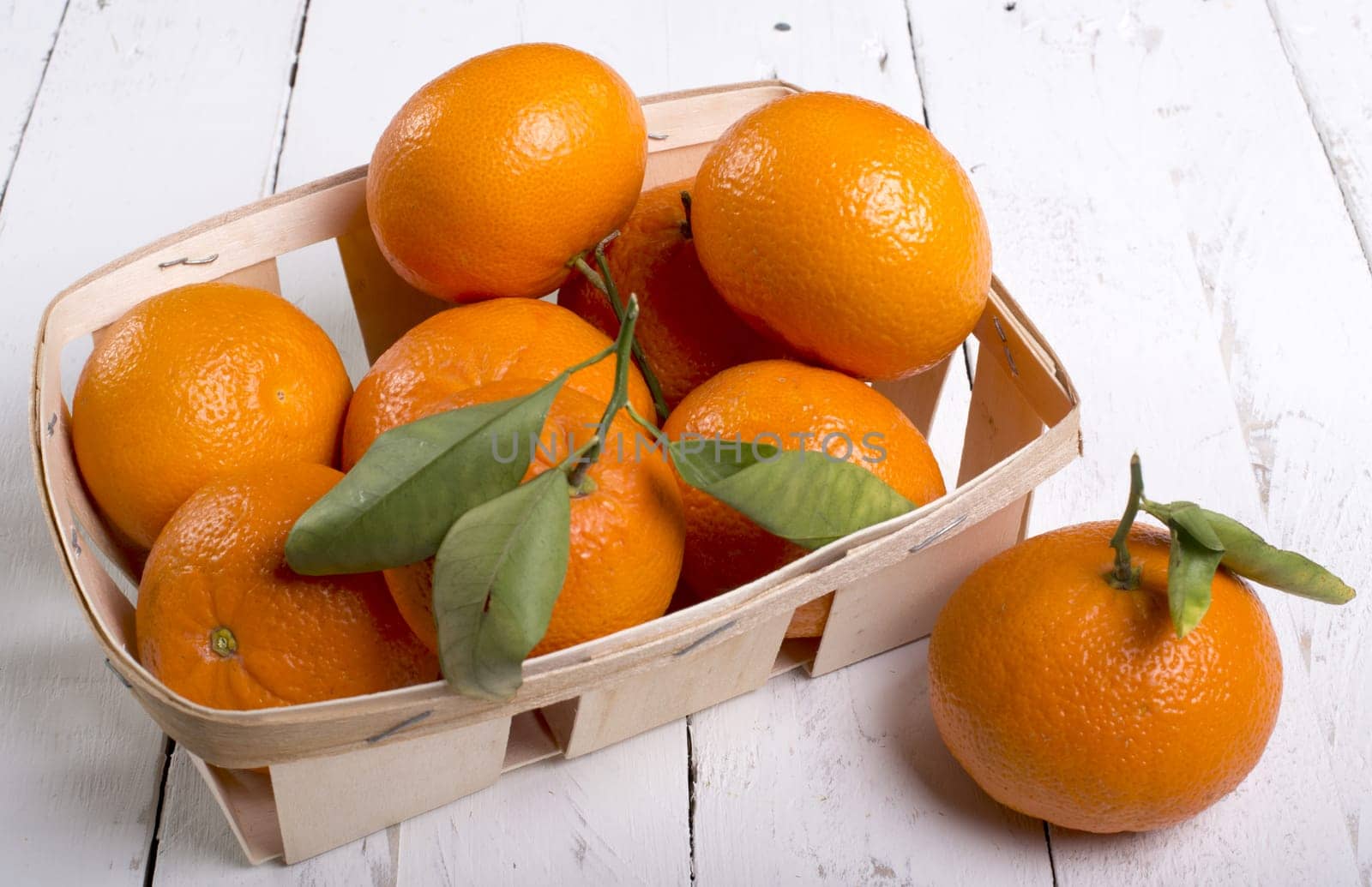 Orange in a basket on wooden planks eve