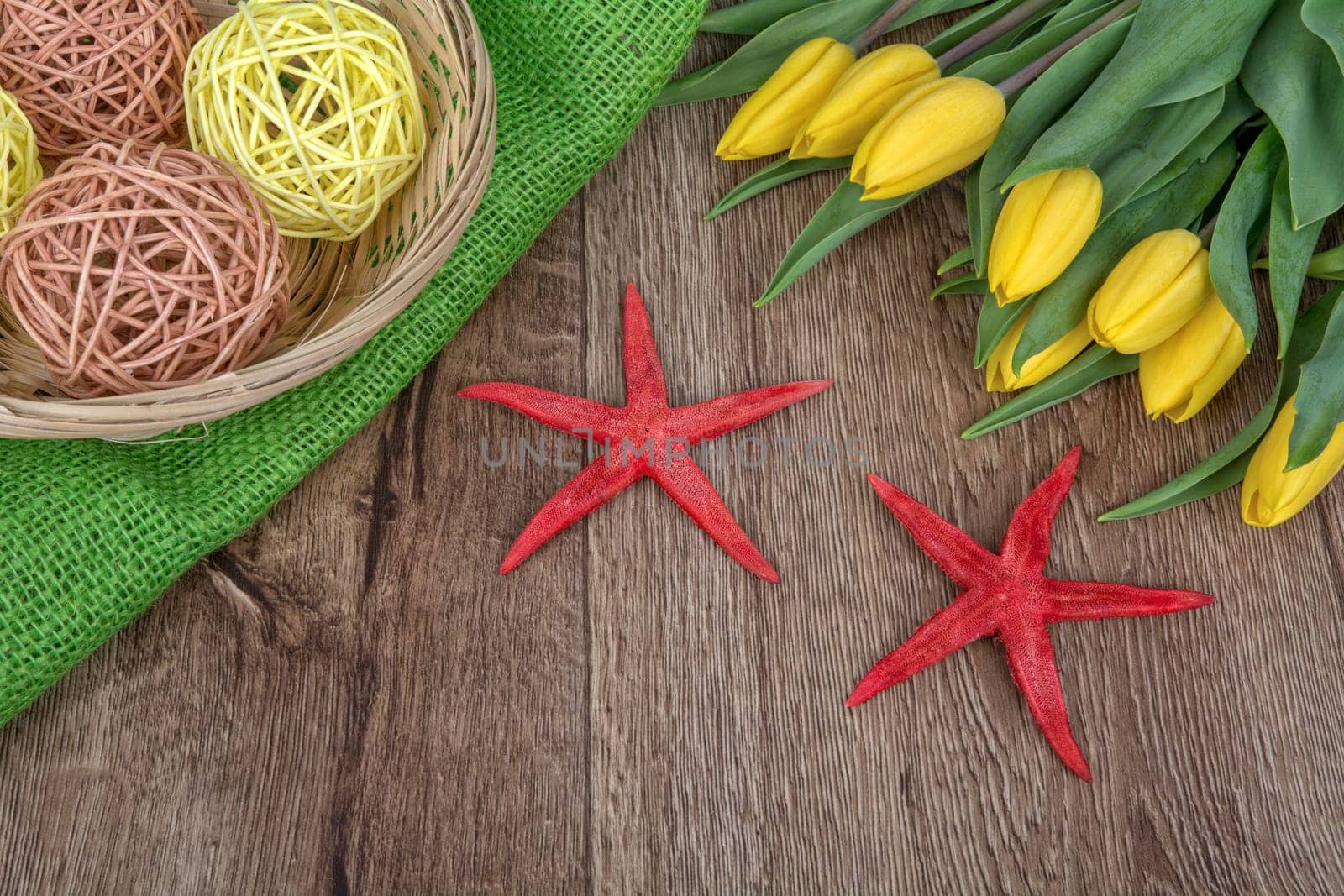 Starfishes and yellow tulips on a wooden background