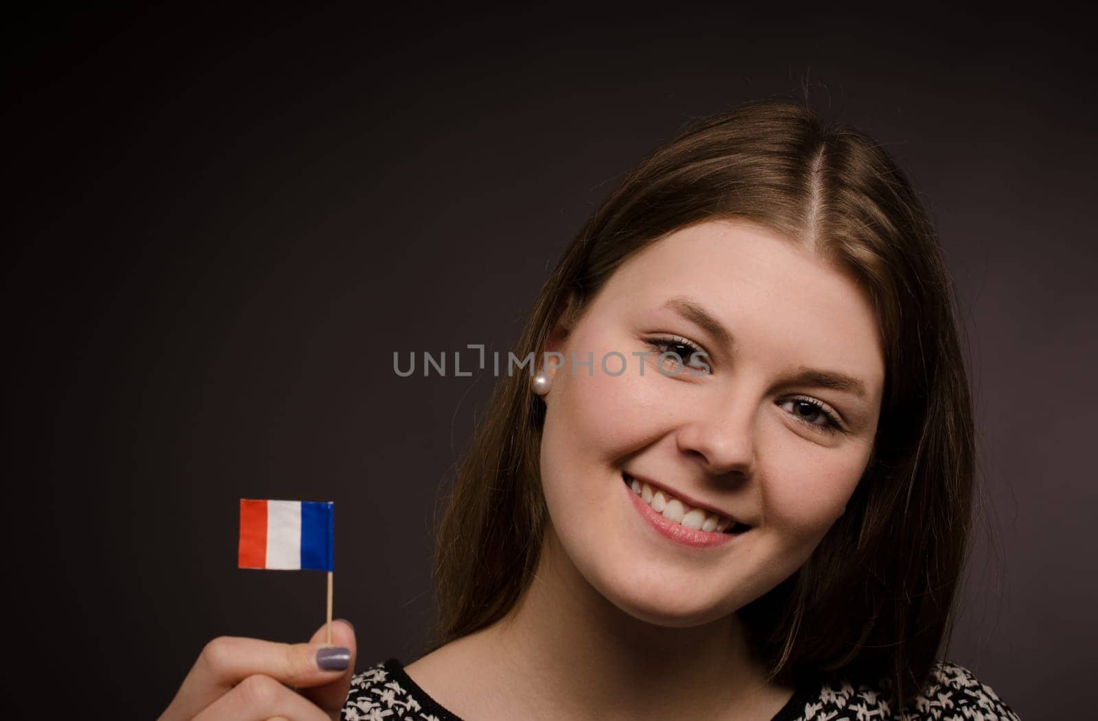 Beautiful smiling woman with a little flag of France