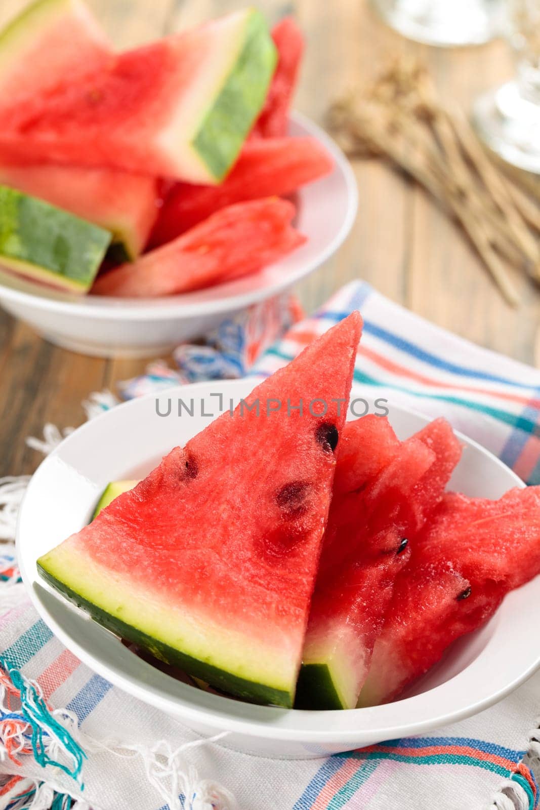 Close-up shot of fresh sliced watermelon in plate. On rustic wooden table.
