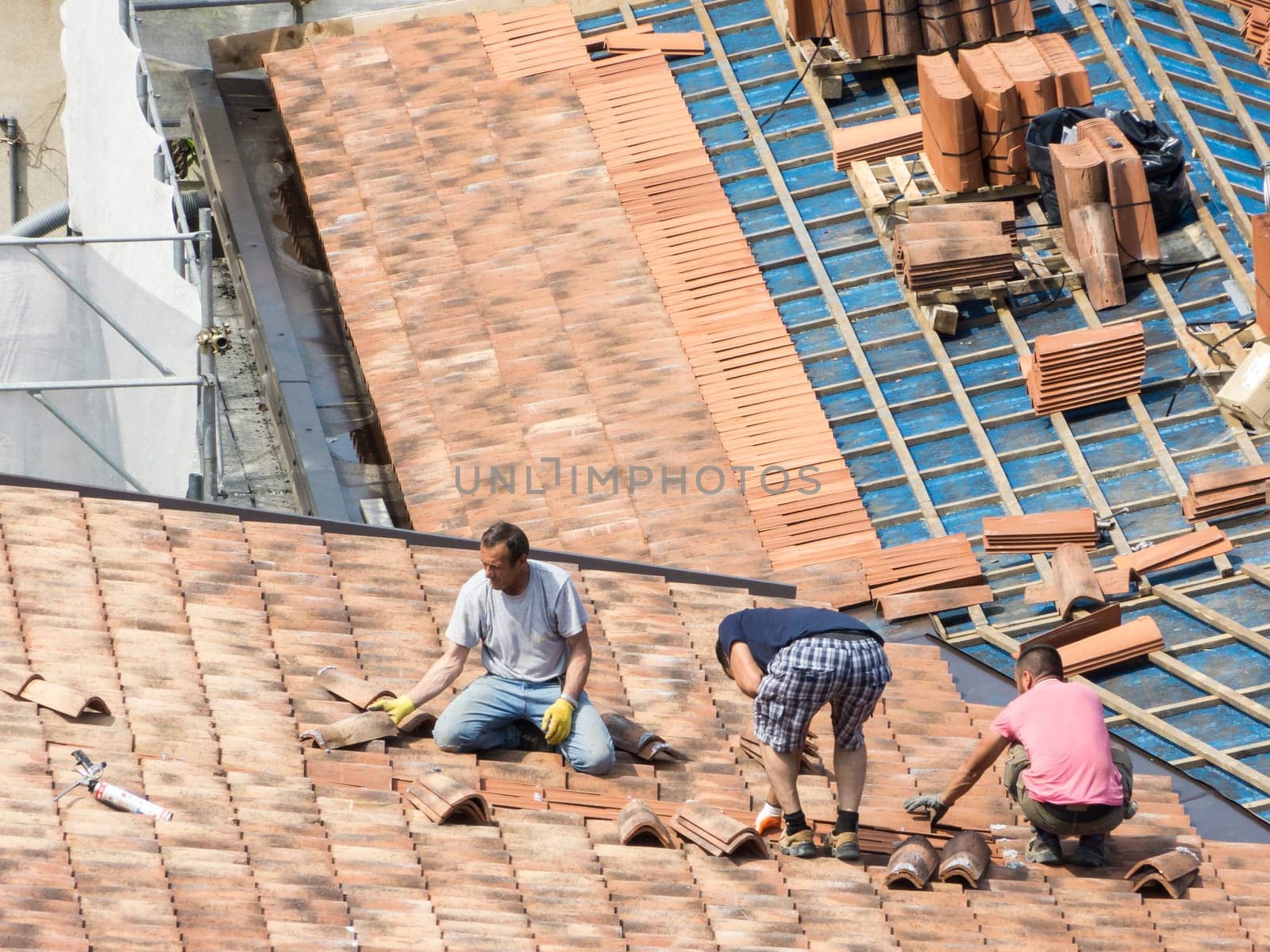 Construction site. Masons to work on the roof for laying tiles