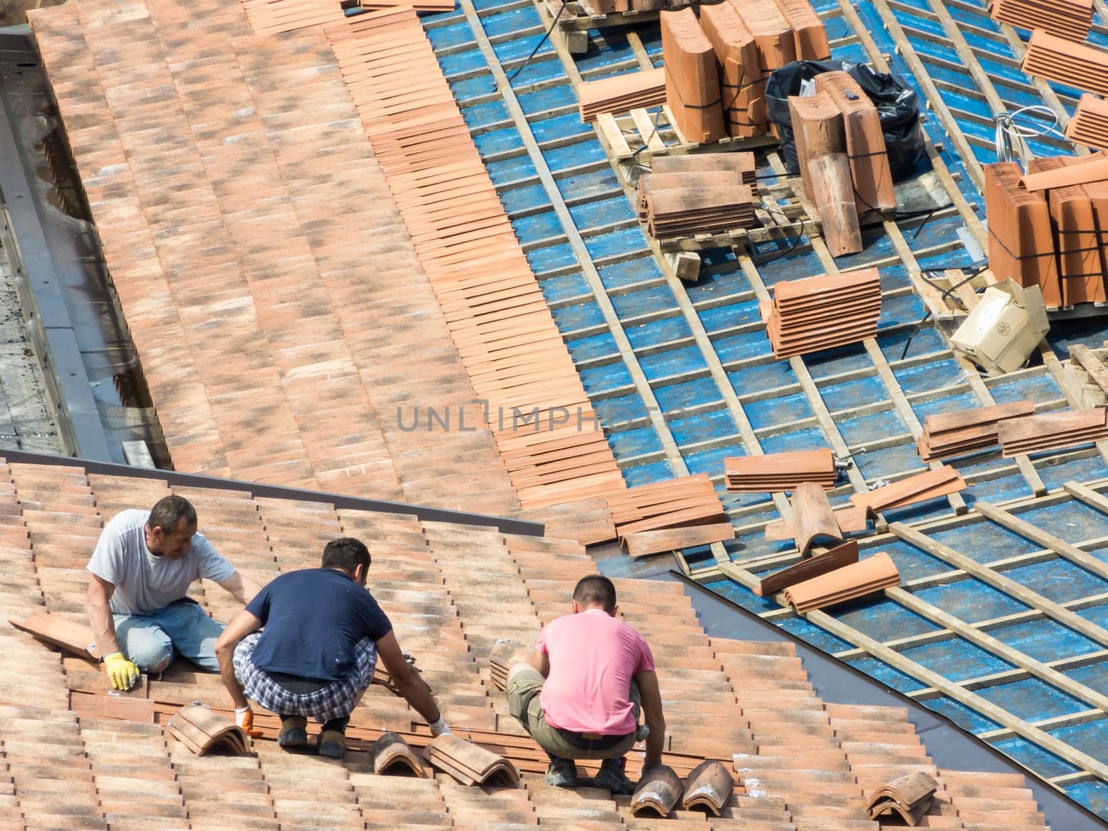 Construction site. Masons to work on the roof for laying tiles
