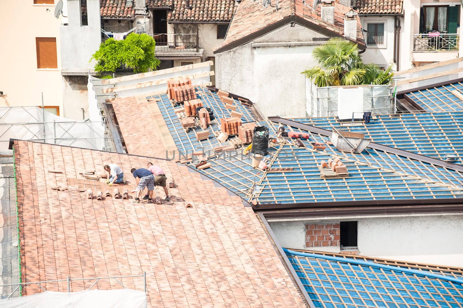 Construction site. Masons to work on the roof for laying tiles