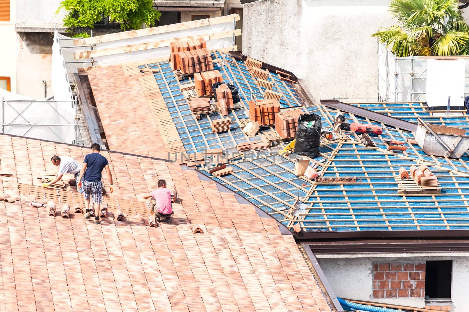Construction site. Masons to work on the roof for laying tiles
