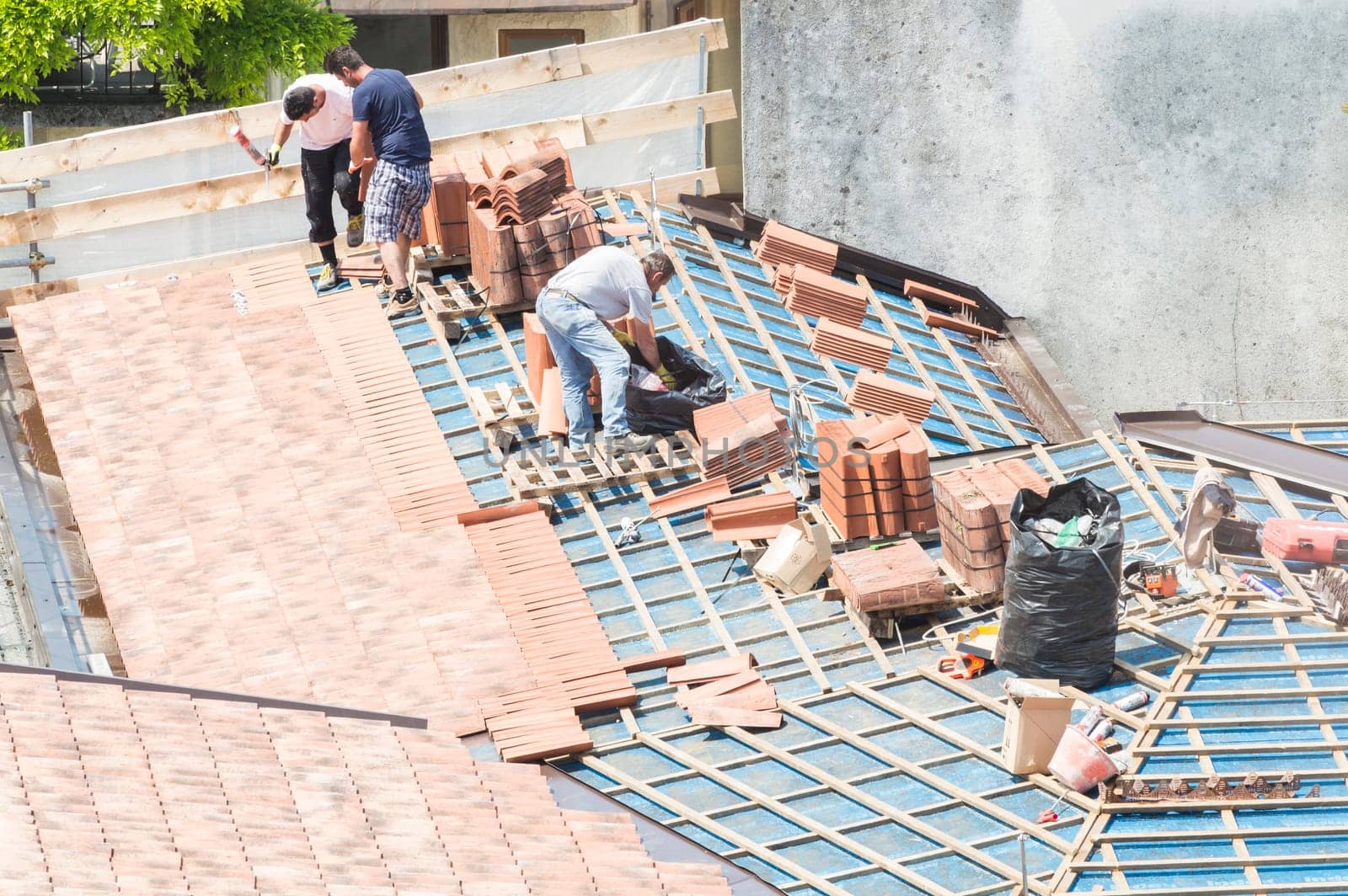 Construction site. Masons to work on the roof for laying tiles