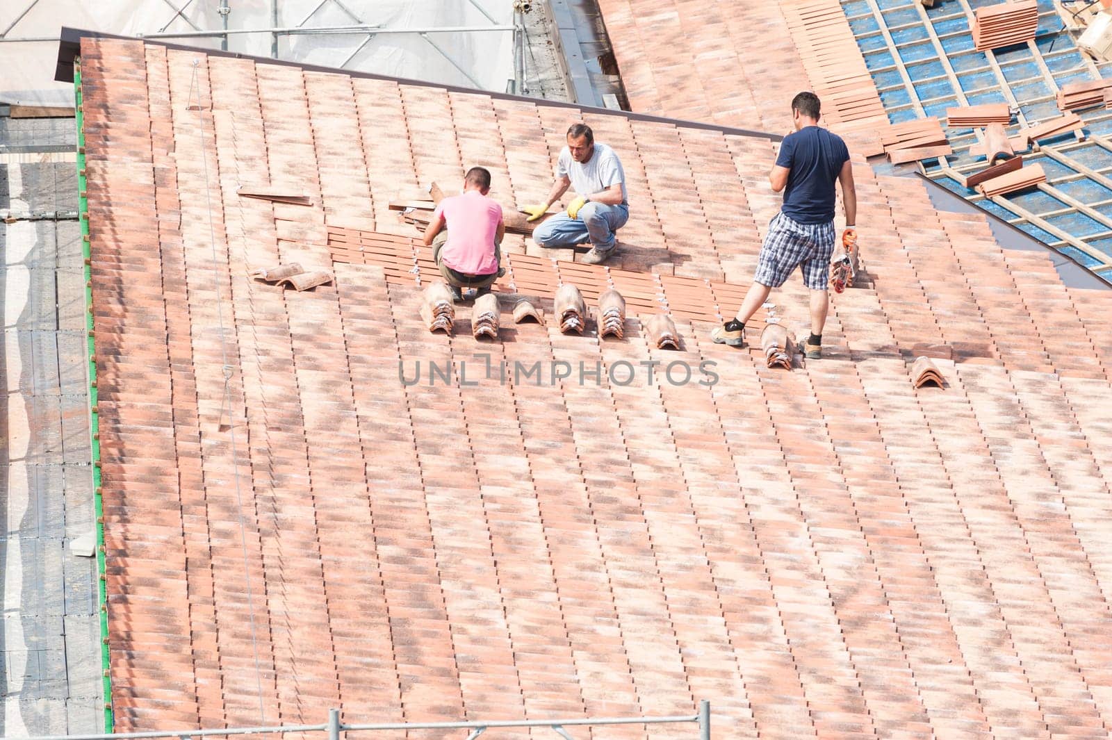 Construction site. Masons to work on the roof for laying tiles