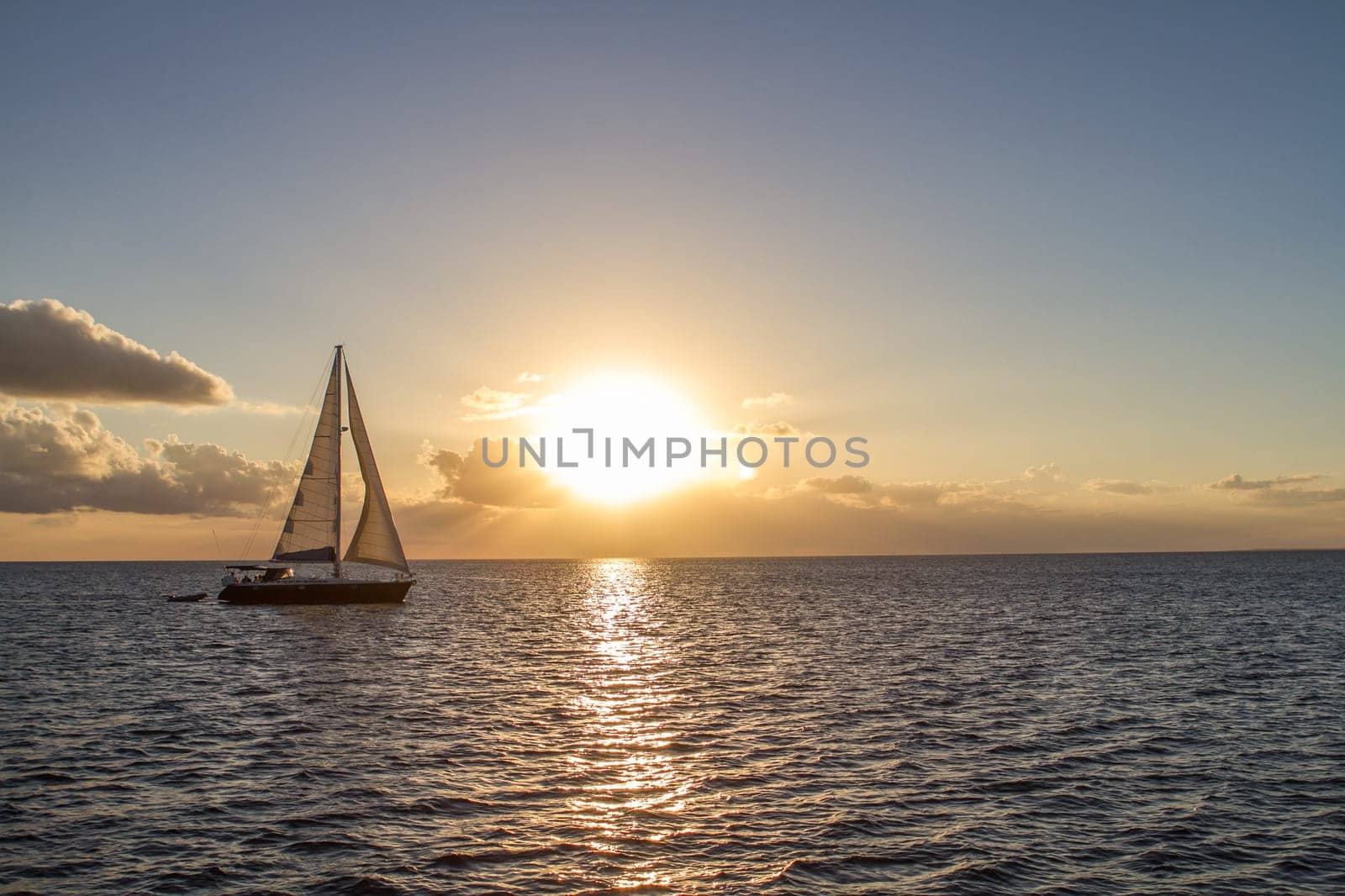 Yacht in the tropical sea at sunset sails
