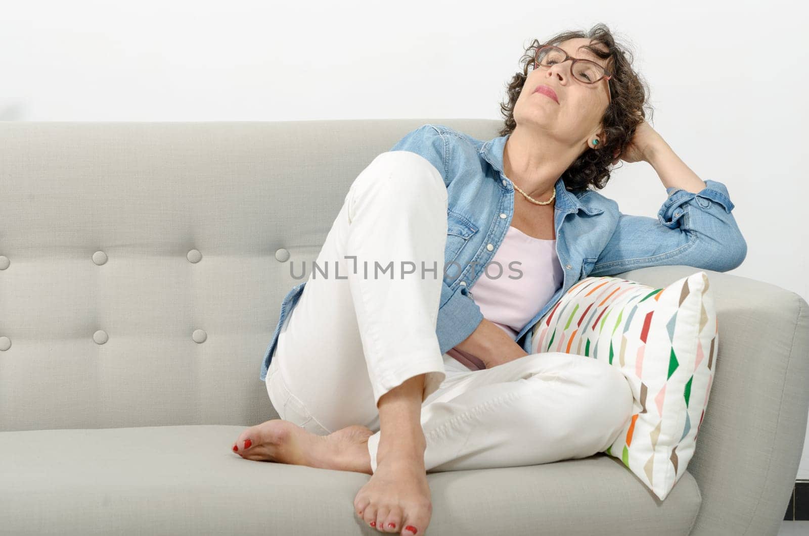 a mature woman relaxing on a sofa