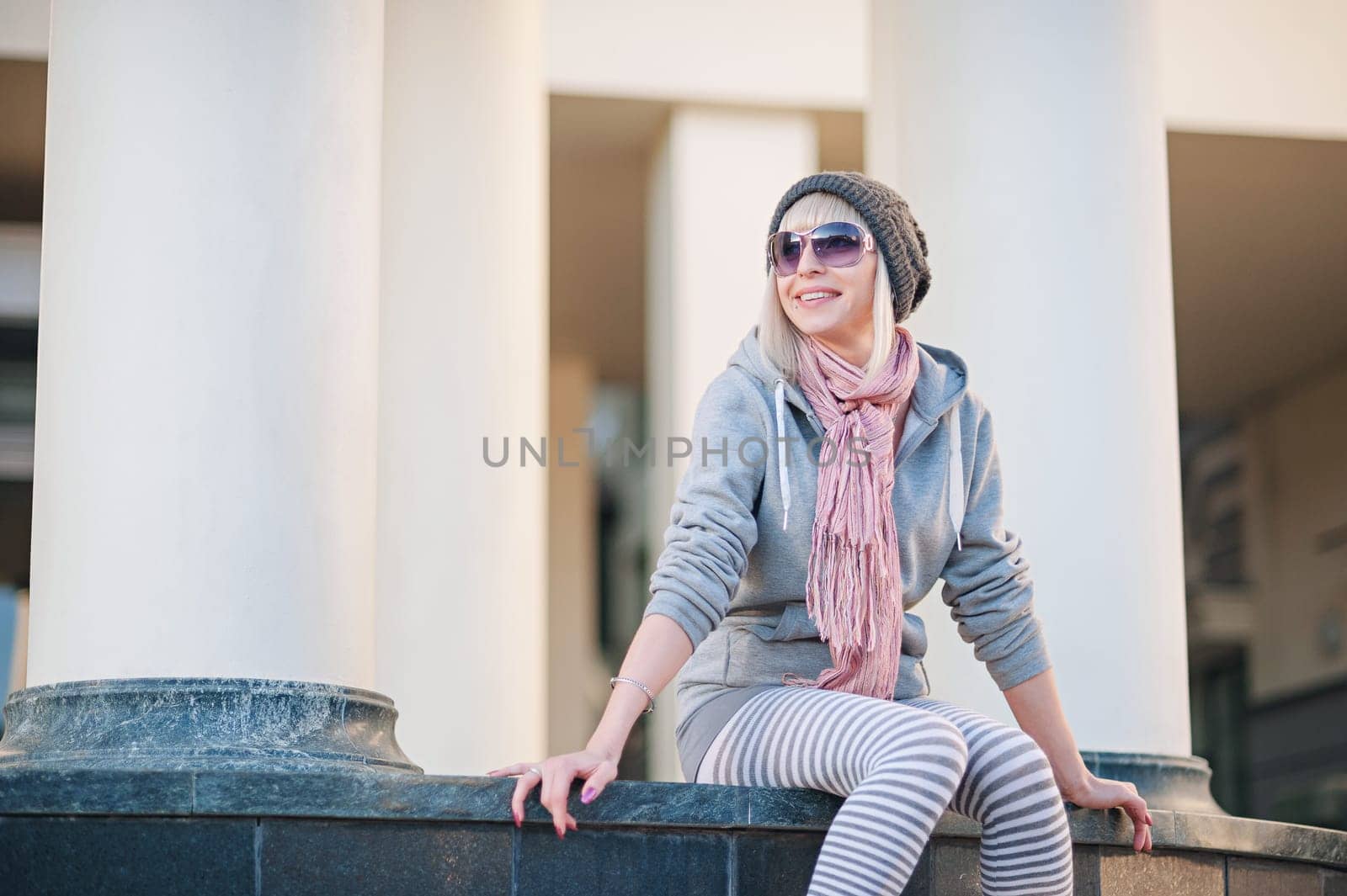 Stylish and fashionable girl on a walk around the city. Black and white knitted hat sneakers, pink socks. Outerwear, warm clothing. Fashionista. clothing items. Autumn clothes.