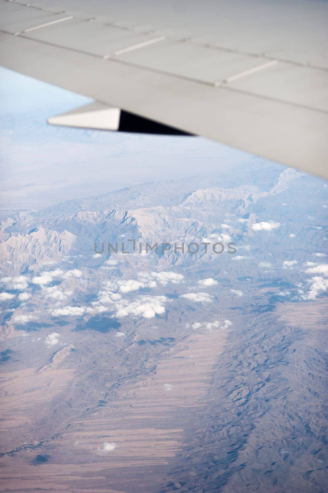 airplane wing above the clouds, blue sky