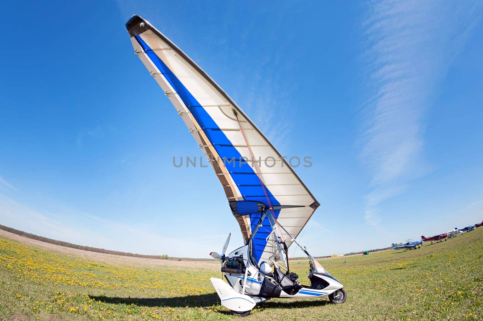 White Motor-glider on a summer meadow waiting for their turn to fly. sunny calm day on the runway. fisheye photo