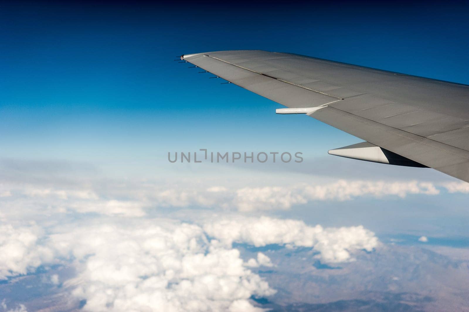 airplane wing above the clouds, blue sky