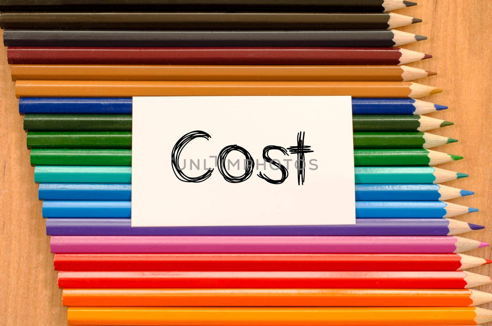 Cost text concept and colored pencil on wooden background