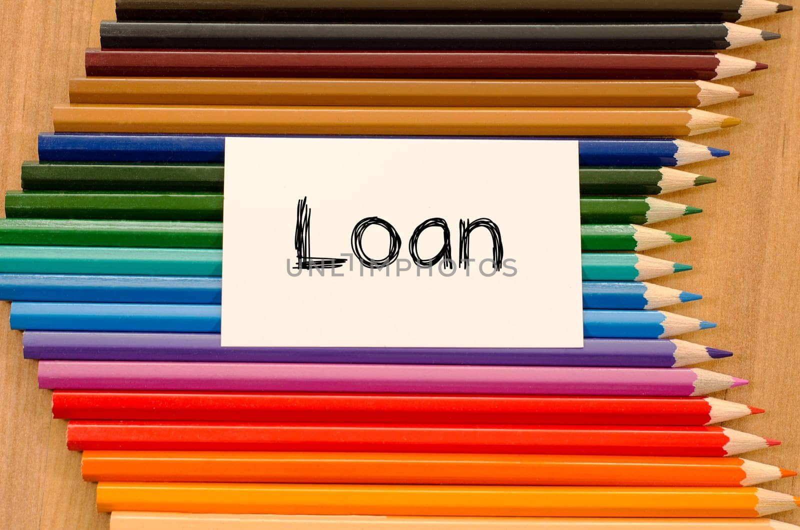 Loan text concept and colored pencil on wooden background
