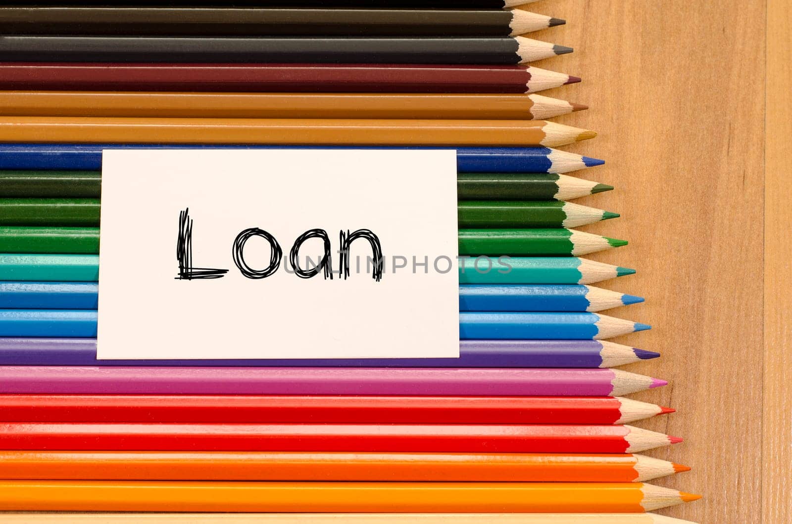 Loan text concept and colored pencil on wooden background