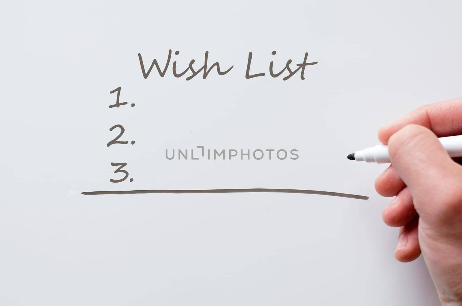 Human hand writing wish list on whiteboard