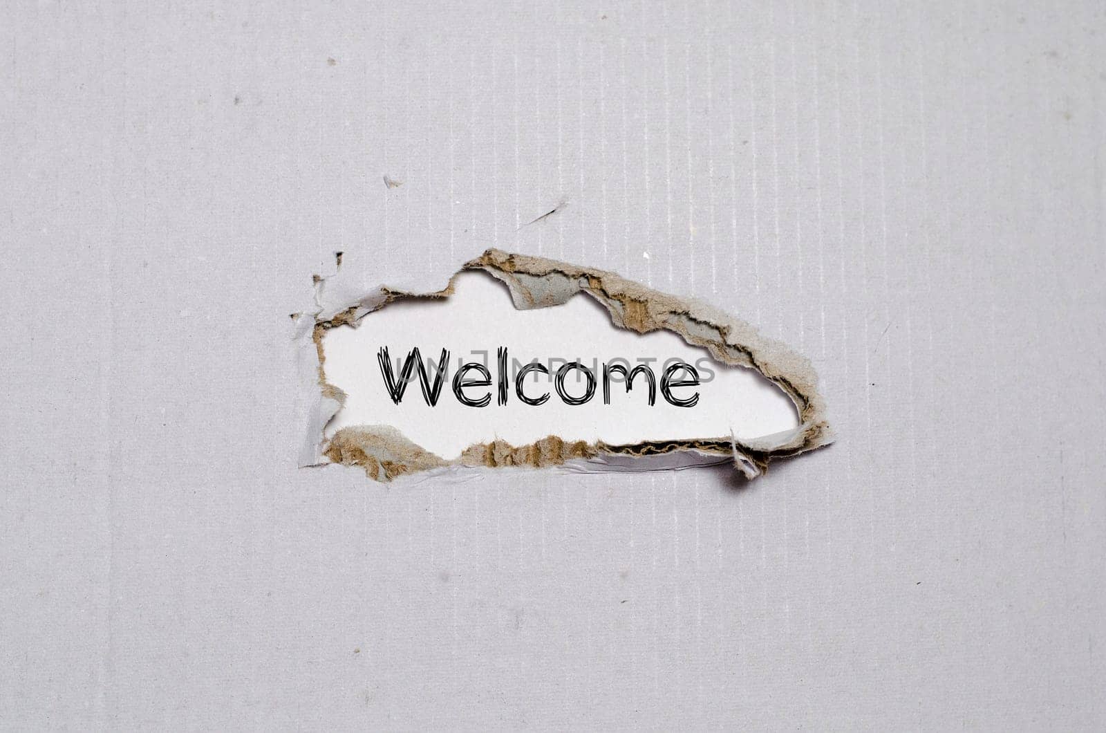 The word welcome appearing behind torn paper.