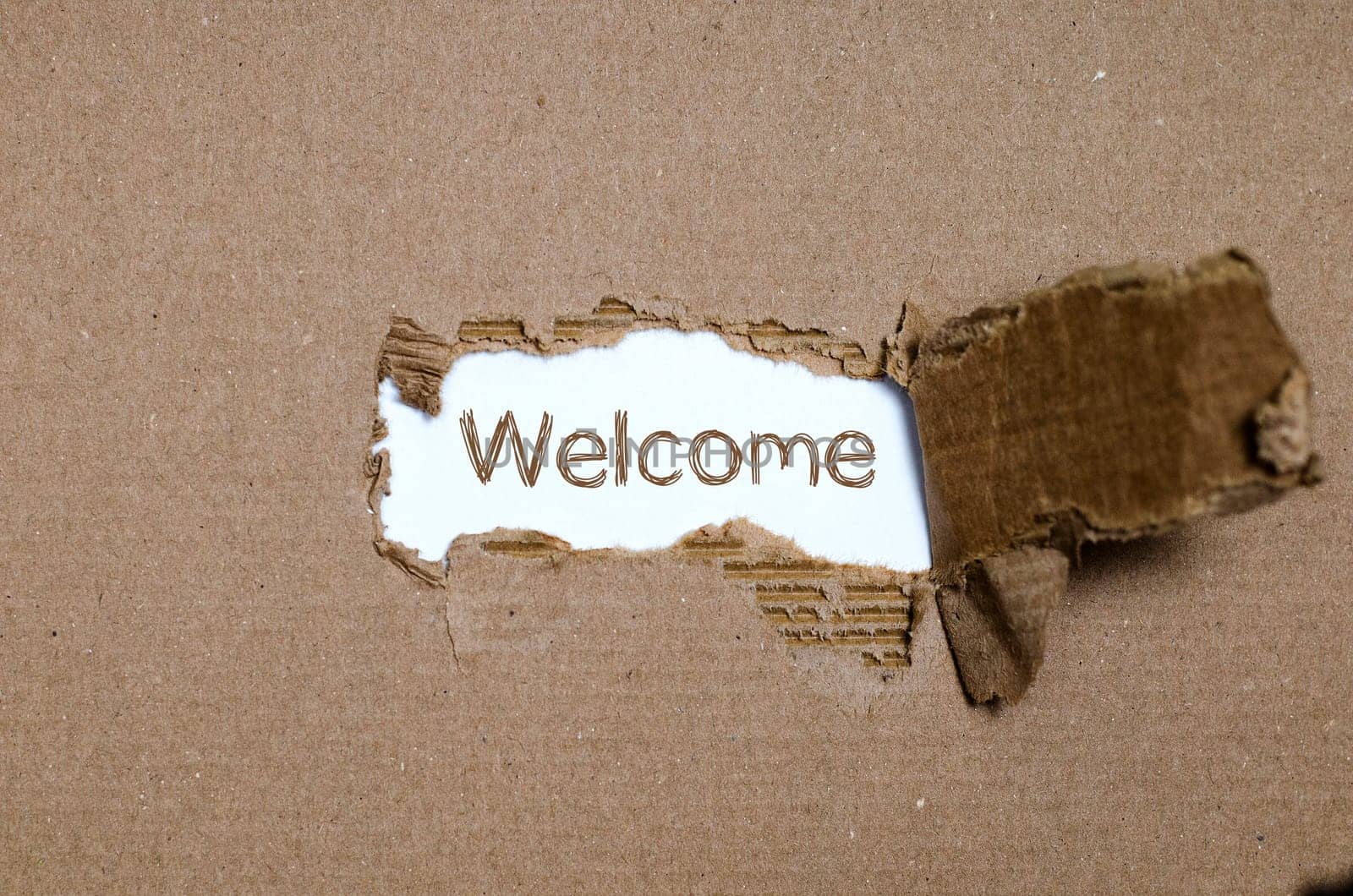 The word welcome appearing behind torn paper.