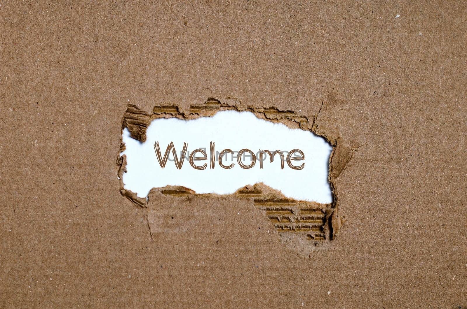 The word welcome appearing behind torn paper.