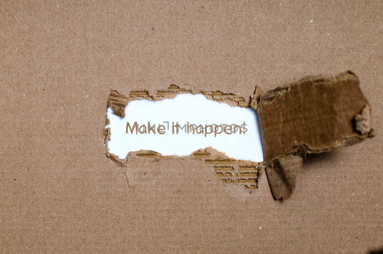 The word make it happen appearing behind torn paper.