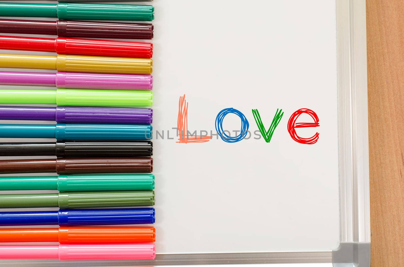 Felt-tip pen and whiteboard on a wooden background