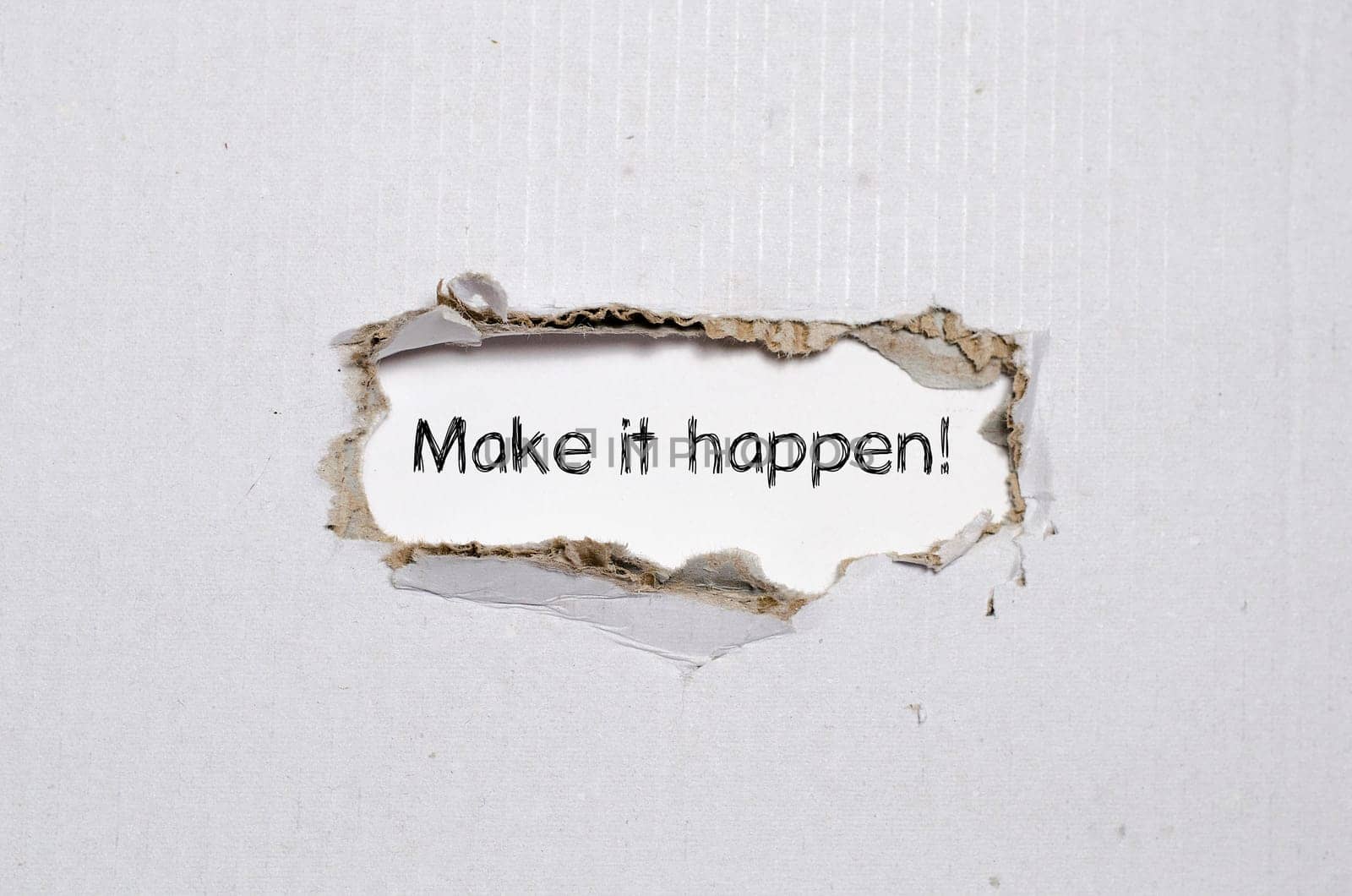 The word make it happen appearing behind torn paper.