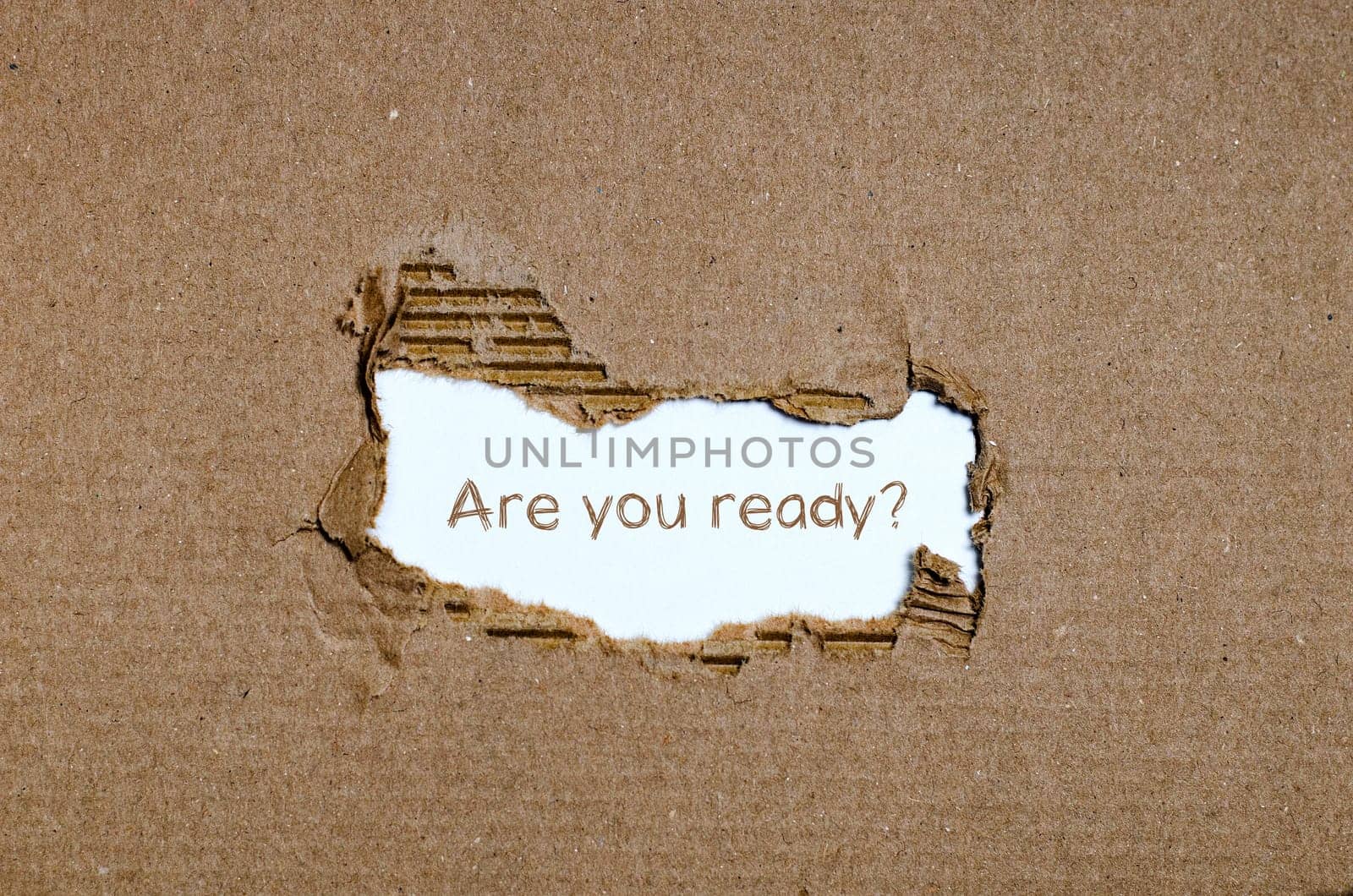 The word are you ready appearing behind torn paper.