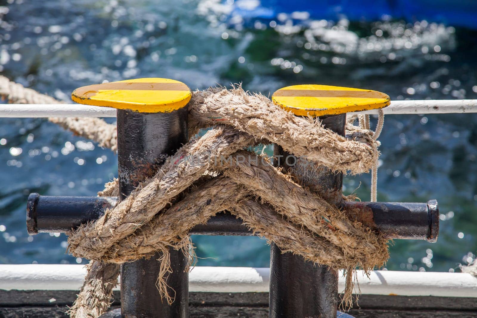 Knotted weathered boat ropes on a blue sea