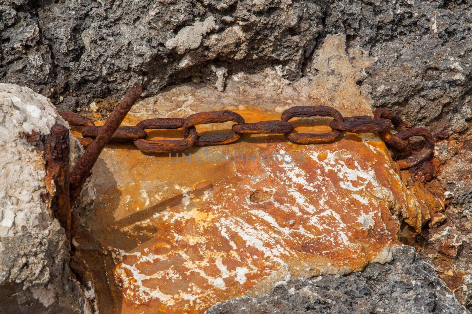 Chain ruined by time and rust on a beach