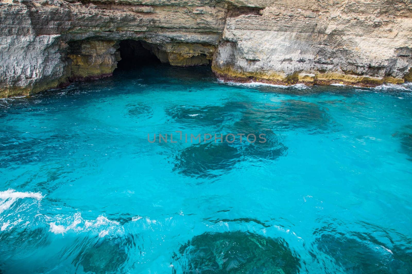 Astonishing light blue sea water in mediterranean sea with a cave