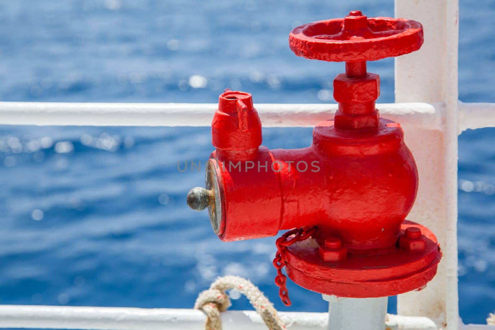 Red fire extinguisher with pipe connector on a boat