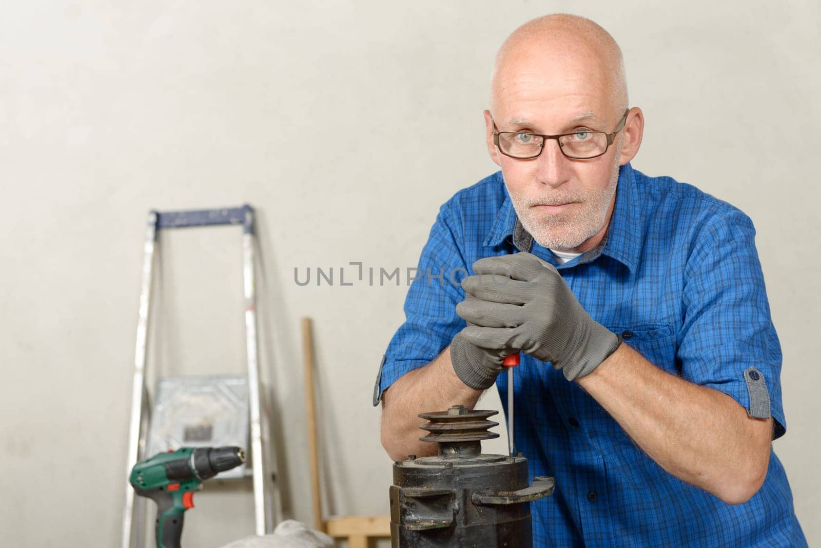 a man with a car generator in his workshop