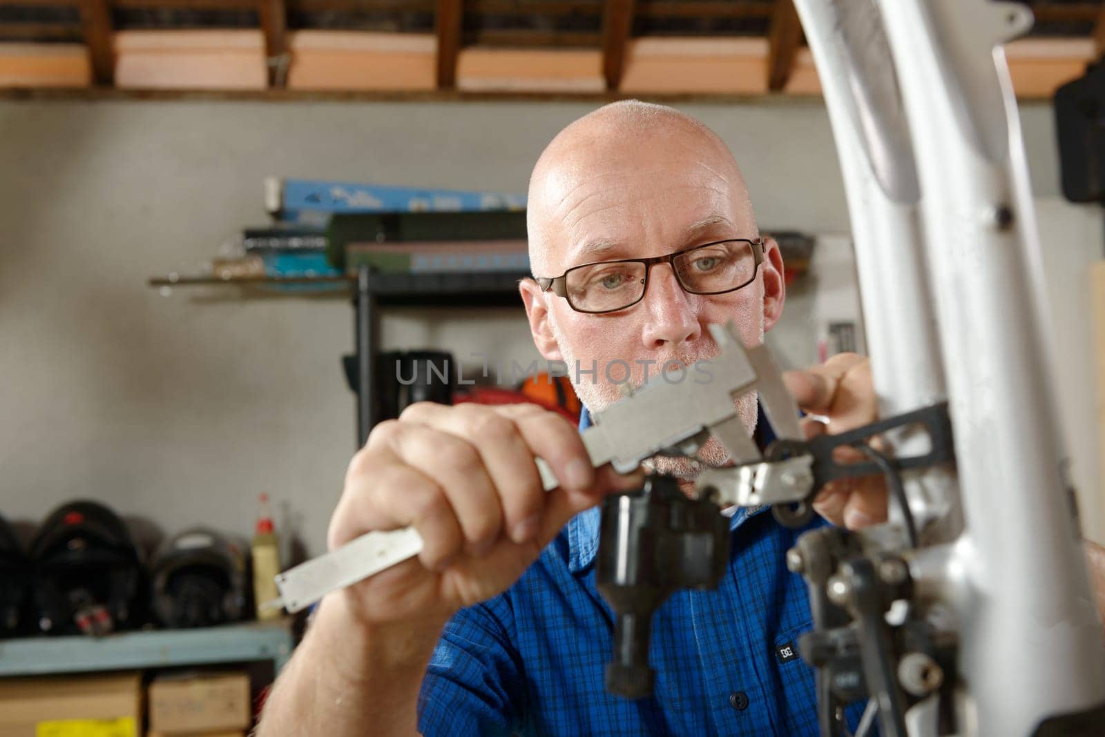 a man repairing bicycle in his workshop.
